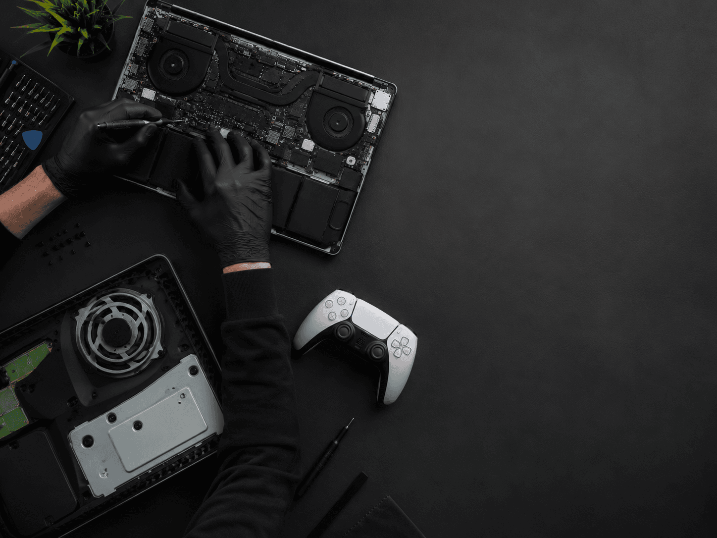 Technician repairing a laptop and games console